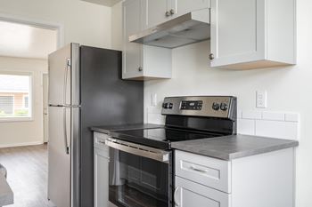 a kitchen with white cabinetry and black appliances